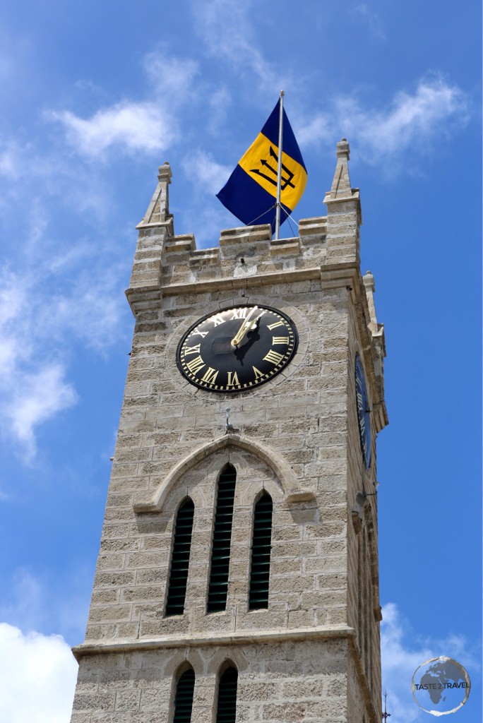 Coral-limestone clock tower in Bridgetown with the Barbados flag.