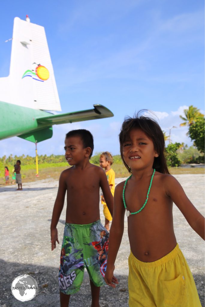 Children playing around the plane at Maiana airport.