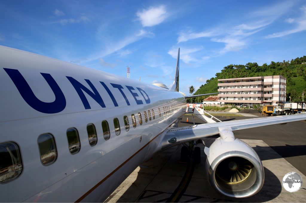 United Airlines' UA154 on the runway at Chuuk International Airport with my hotel, Hotel Level 5, visible in the background.
