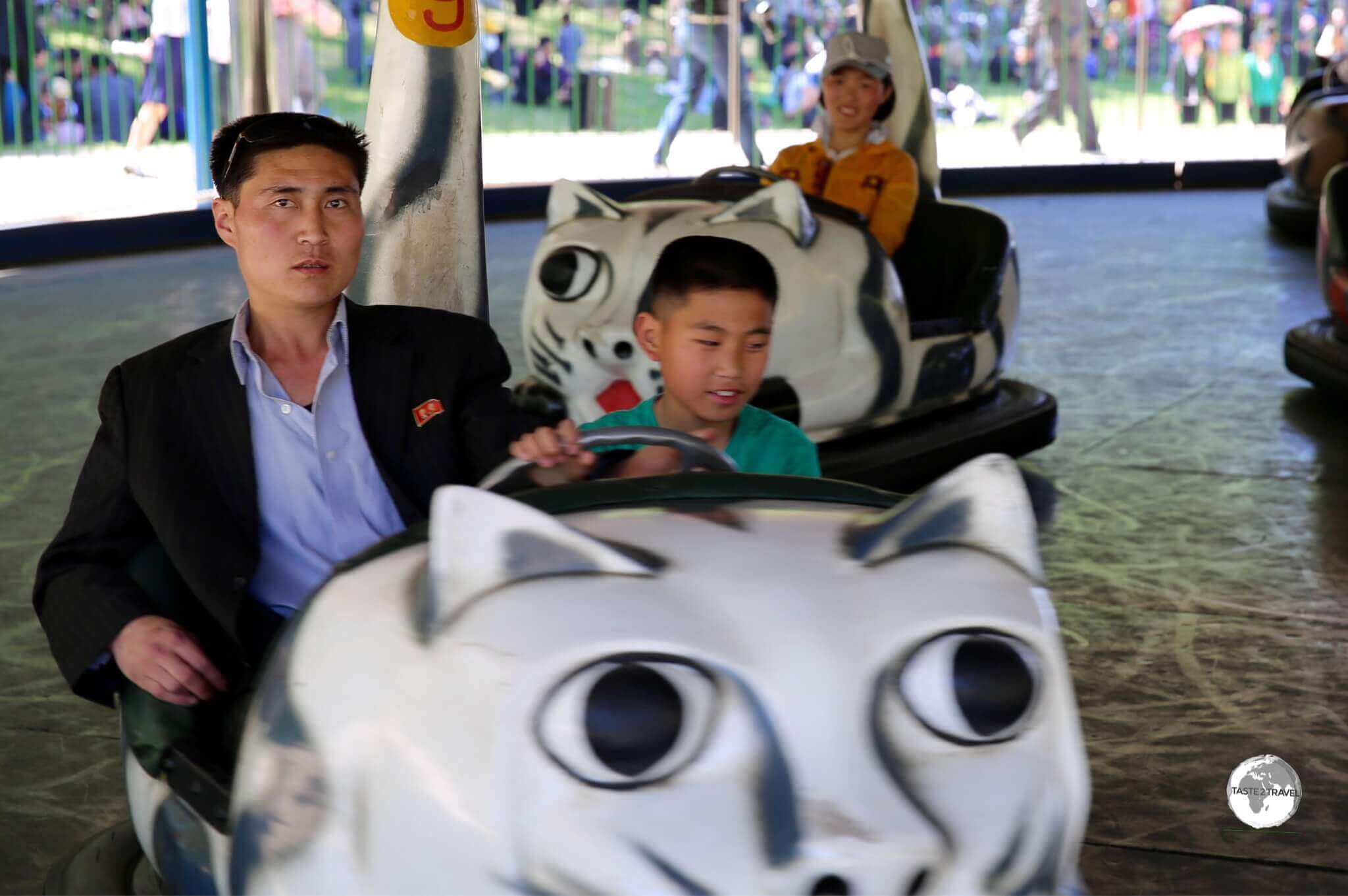 Father and son riding the bumper cars at Taesongsan Fun Fair in Pyongyang.