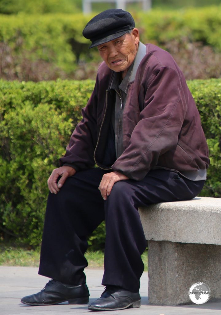 An elderly man relaxing in the park at the 'Monument to Party Founding' in Pyongyang.