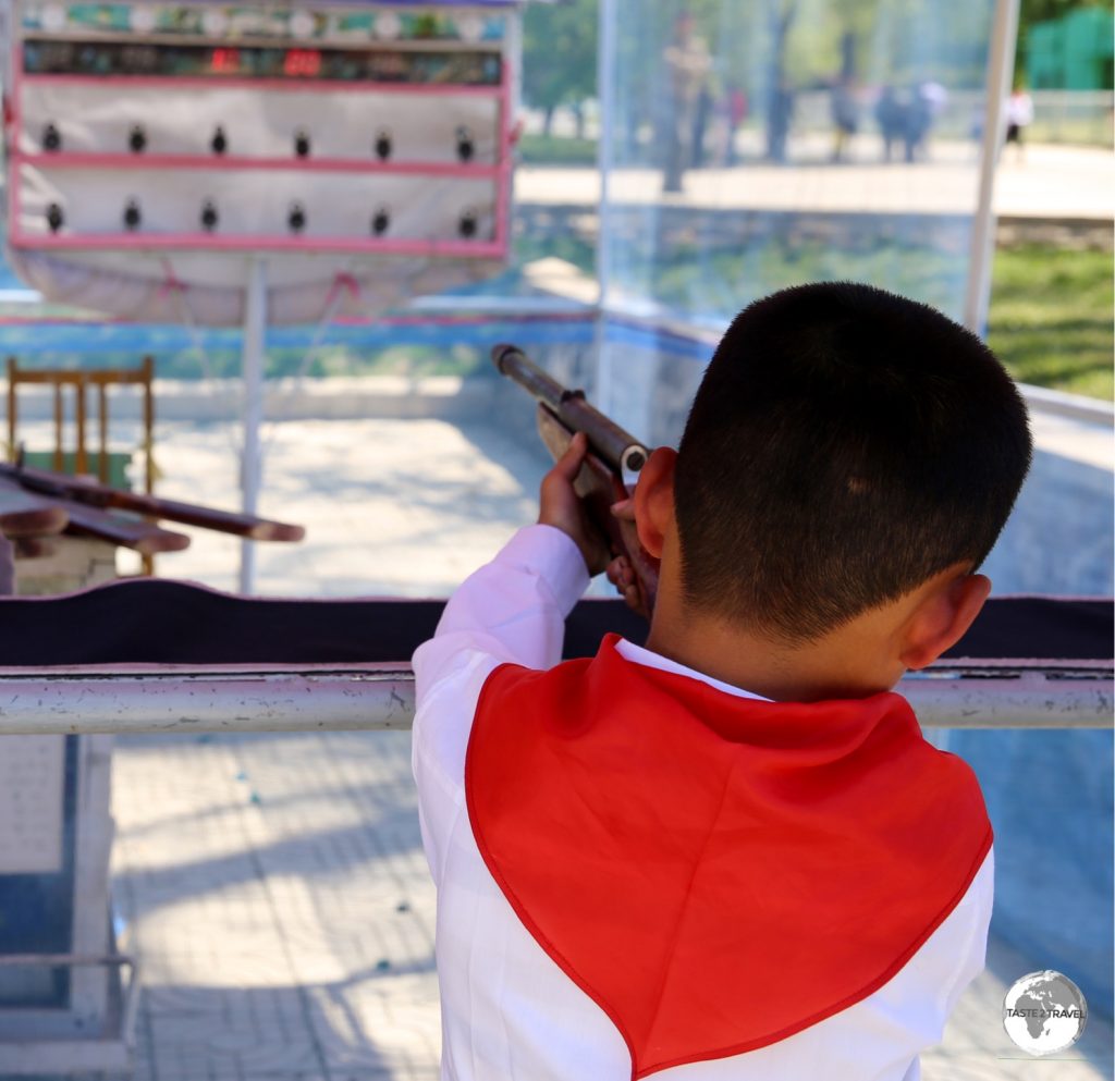A young school boy tries his luck at the shooting alley at Mt Taesong Amusement park.