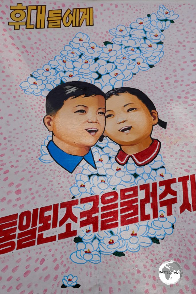 A propaganda billboard at the DMZ depicts a reunified North and South Korea. The Koreas are often depicted as brother and sister in North Korean propaganda.