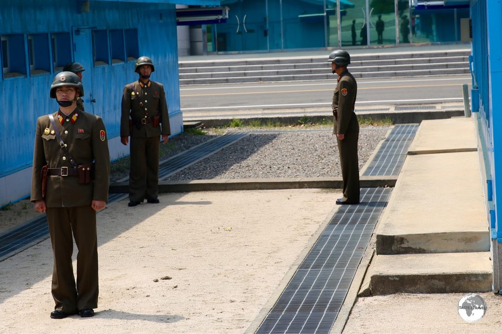 The low concrete ridge running between the huts marks the border between North and South Korea.