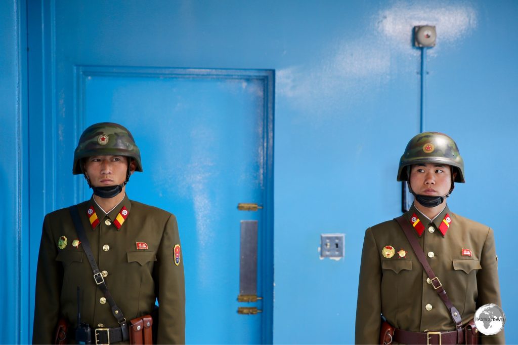 The blue door is the exit to South Korea. The guards ensure no one leaves the room through this door.