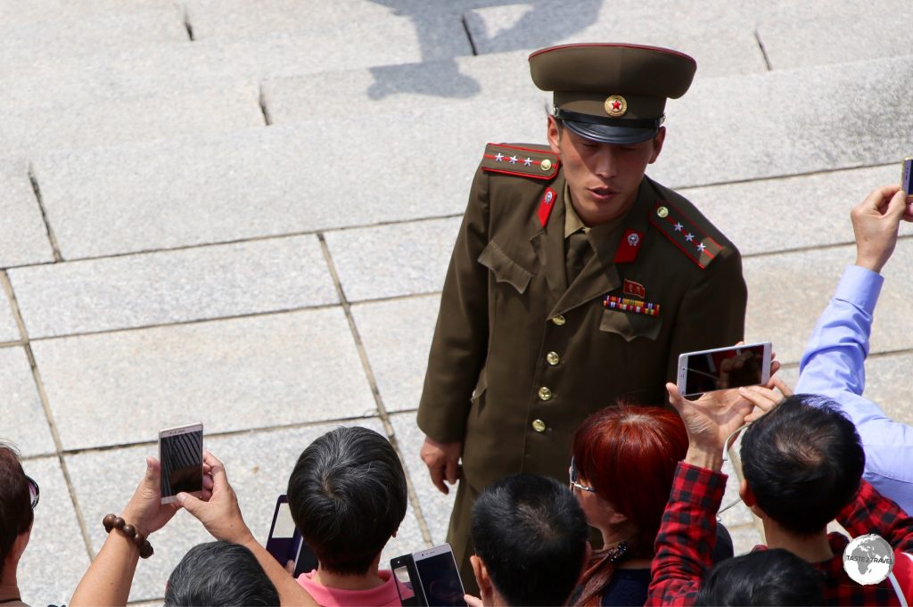 A North Korean soldier conducting a tour of the DMZ with a group of Chinese tourists.