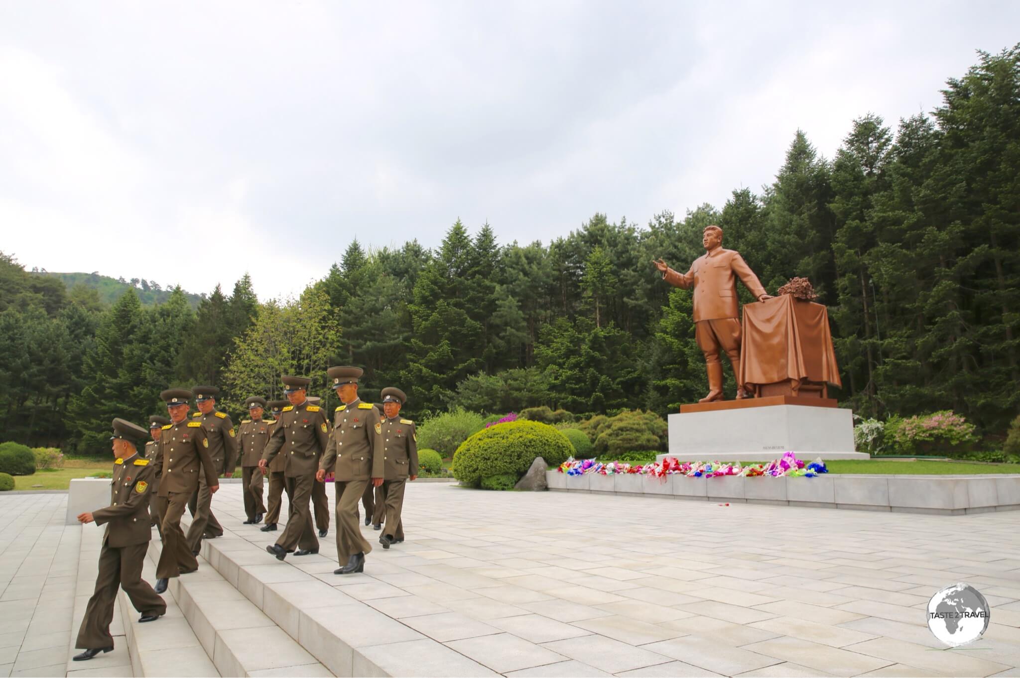 North Korean soldiers visiting a statue of Kim Il-Sung in a park on the outskirts of Pyongyang.