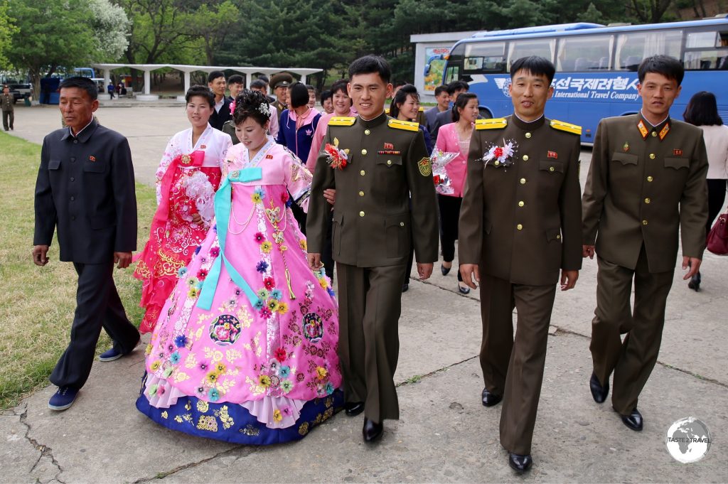 Newlyweds on their way to pay their respects at a statue of the dear leader.