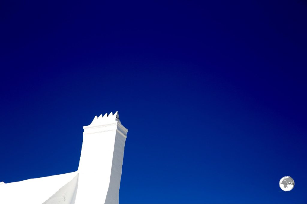 White chimney against a brilliant blue sky.