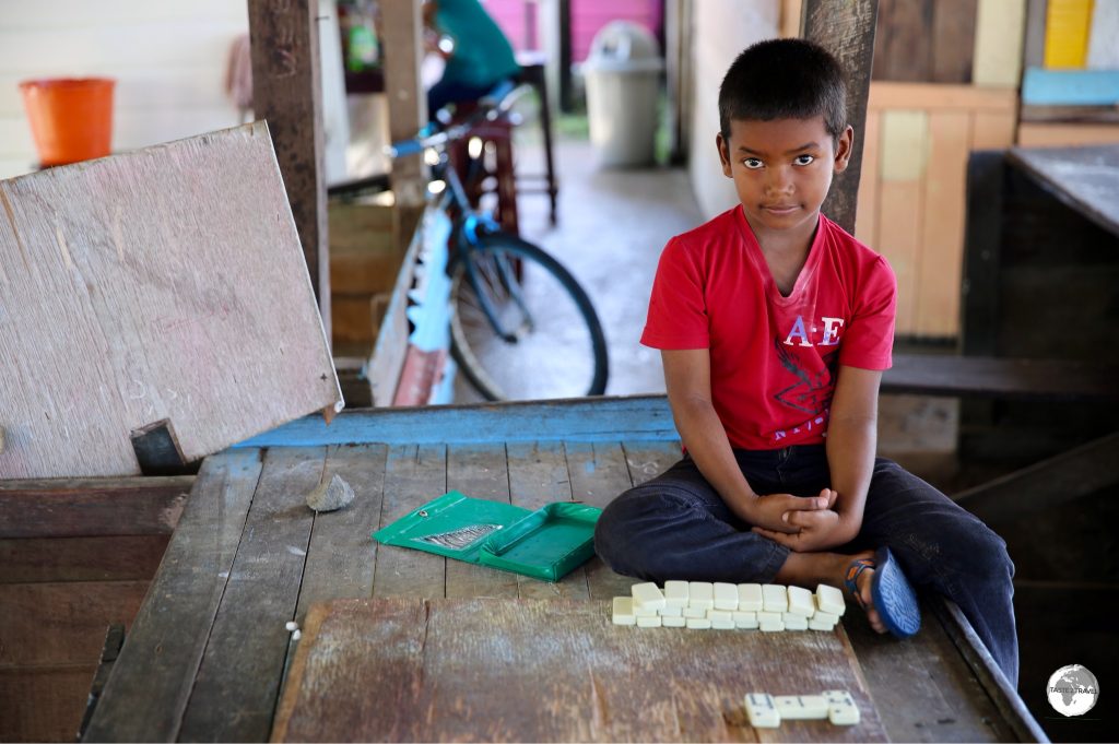 Young boy at the dock in Charity playing dominoes.