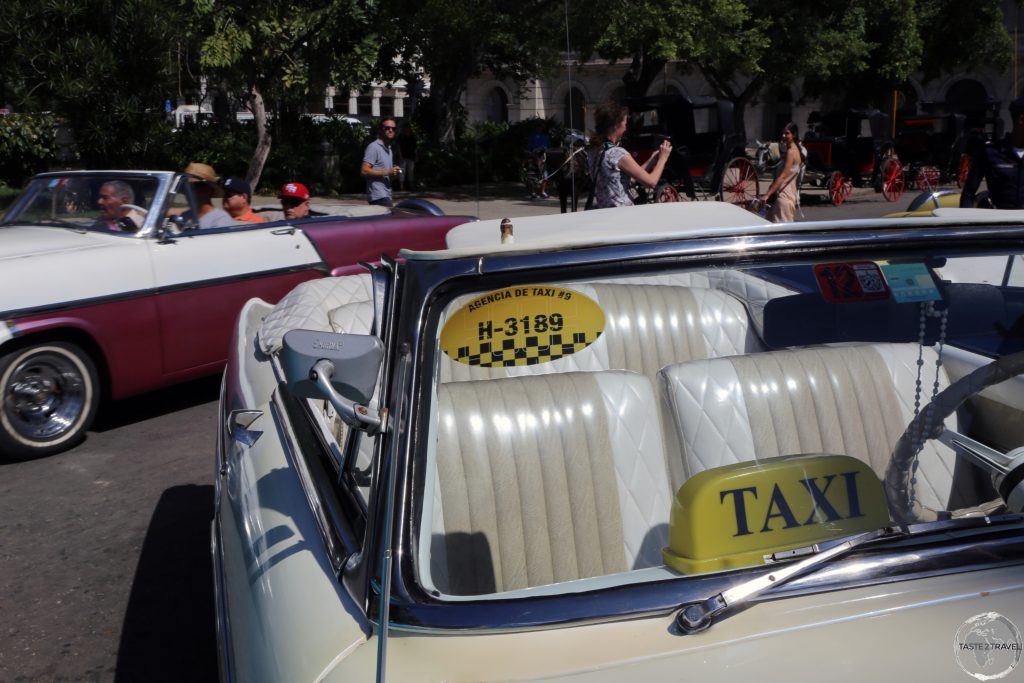 Beautifully maintained American classic car taxis outside the Hotel Inglaterra in Havana.