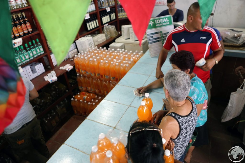 Lining up to buy orange soda which had just arrived by the pallet load at a shop in Cigar maker working in a factory in downtown Sancti Spíritus.