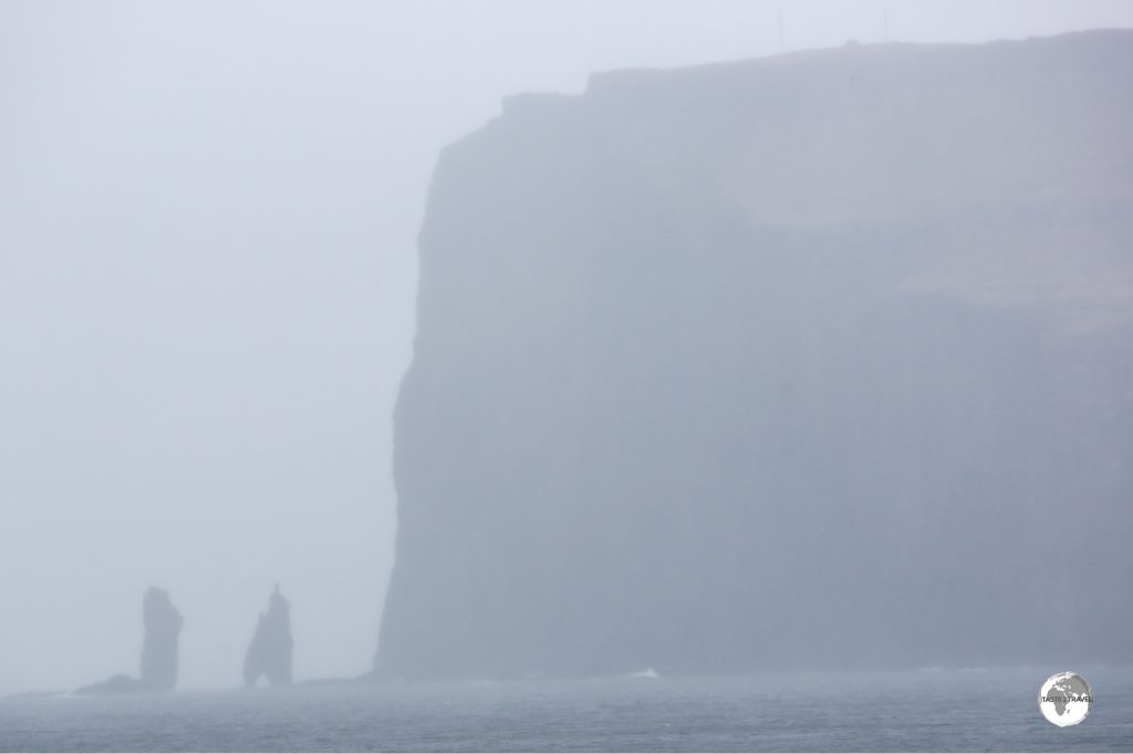 A view of the soaring 343-metre-high Eiðiskollur promontory with the two 75-m high sea stacks - Risin og Kellingin.