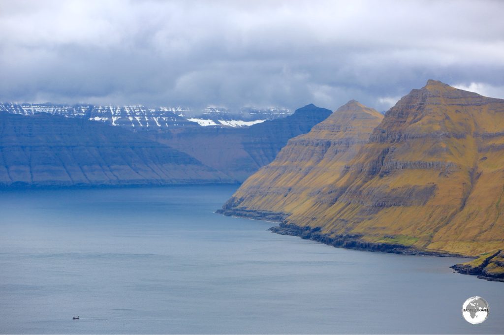 A boat (bottom left) is dwarfed by the towering peaks which surround the Funnings Fjord on Eysturoy Island.