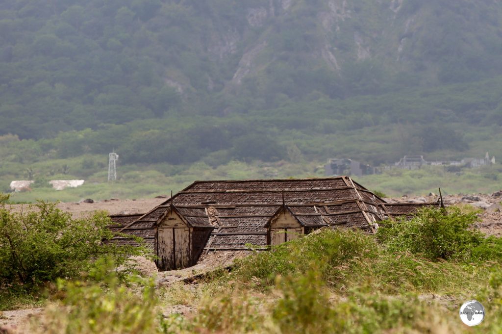 Swallowed by mud flows, only the roof of this building remain visible.