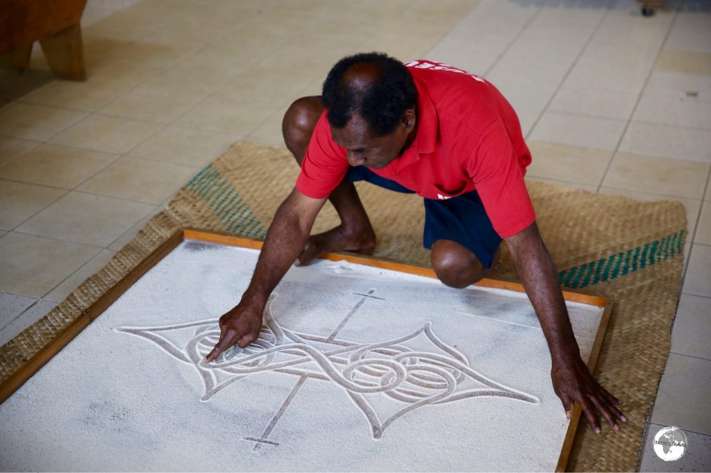 Edgar Hinge of the National Museum, telling a story using the ancient art of Sand-drawing.