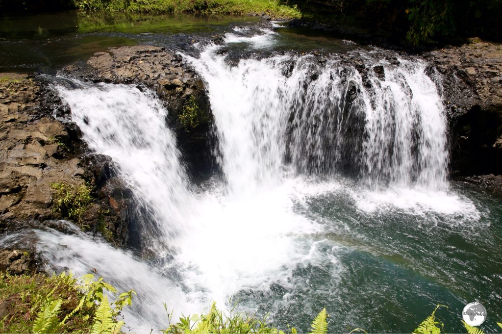 Surrounded by lush vegetation, the Togitogiga Waterfalls are a popular swimming hole.