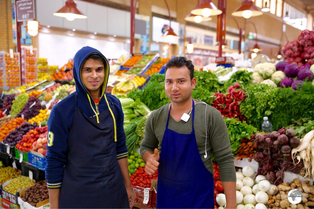 Guest workers constitute 70% of the population and can be found working everywhere, including at the local produce market.
