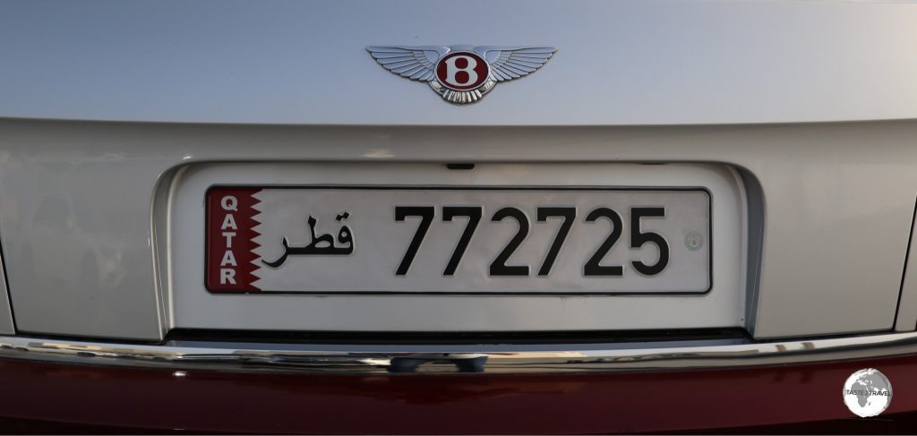 A Bentley logo in Qatari purple. All Qatari license plates feature the national flag.