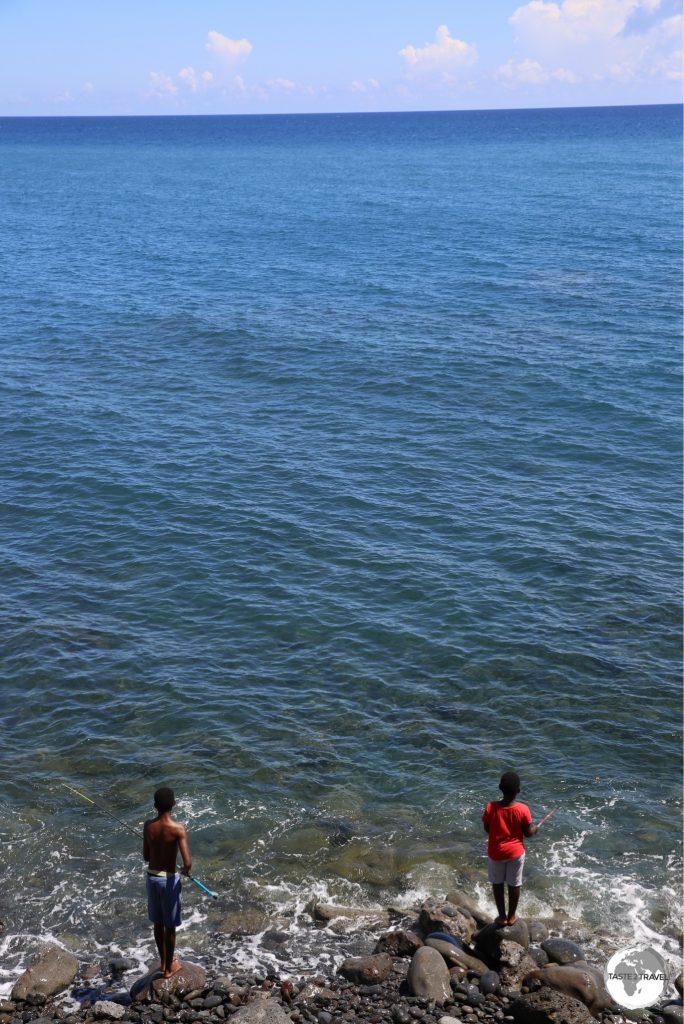 The clean waters of the Indian ocean provide an ideal fishing ground for two local boys, seen here at Le Barachois.