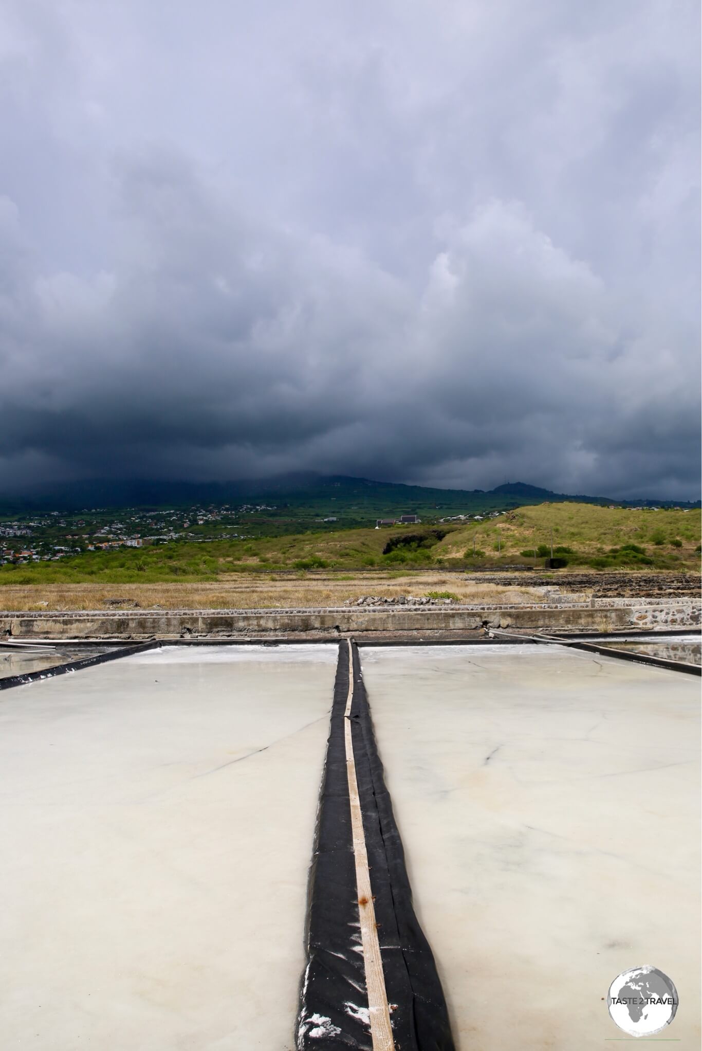 While the upper slopes of the volcano receives frequent rainfall, the nearby salt pans, which lie in a rain shadow, remain mostly dry.