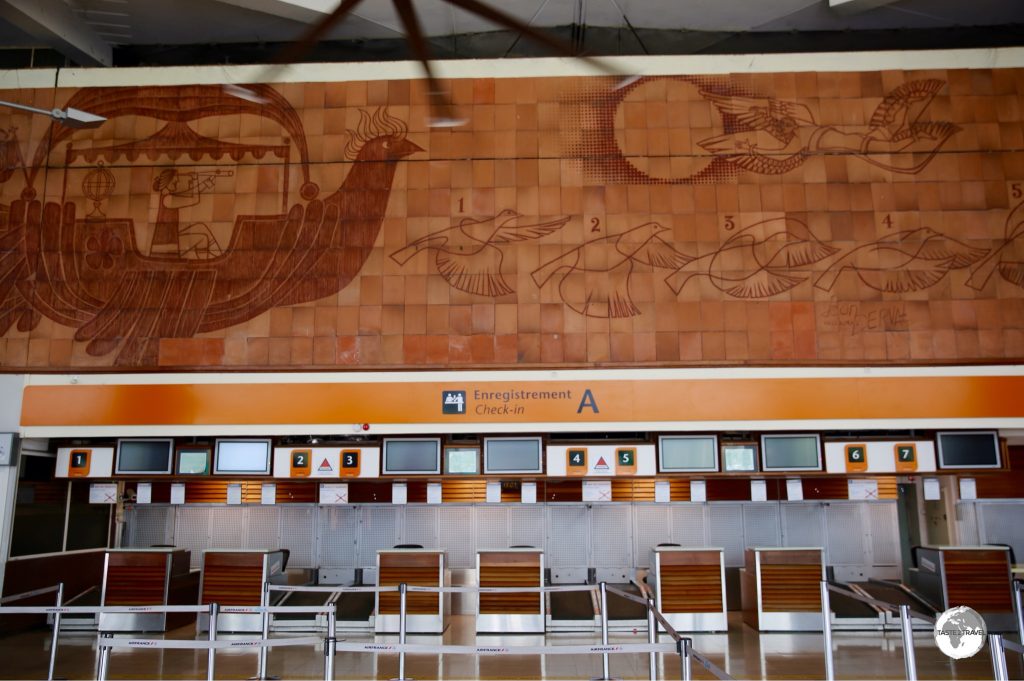 A giant terracotta mural adorns the departure hall at Roland Garros International Airport.