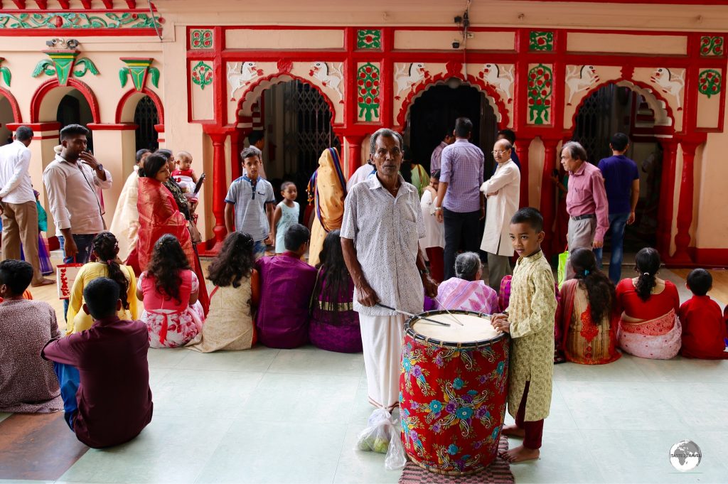 A drummer in front of the main temple at Dhakeshwari Temple.