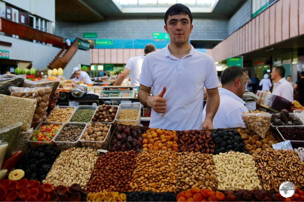 A vendor at the Green Bazaar selling dried fruits and nuts at bargain prices.