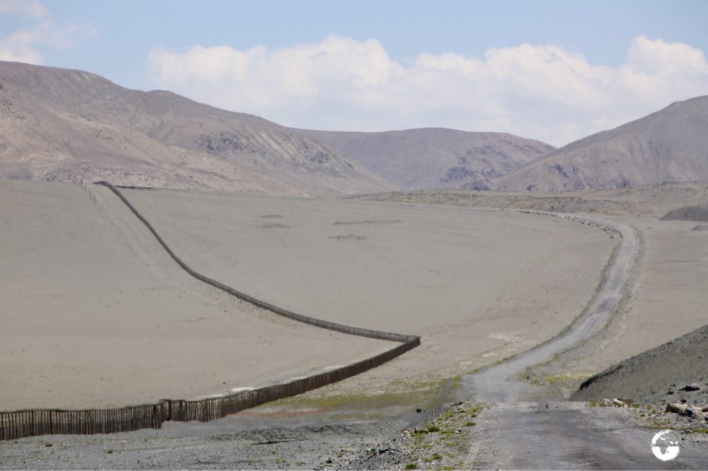 The Pamir highway travels alongside the barbed-wire fence of the Chinese border.