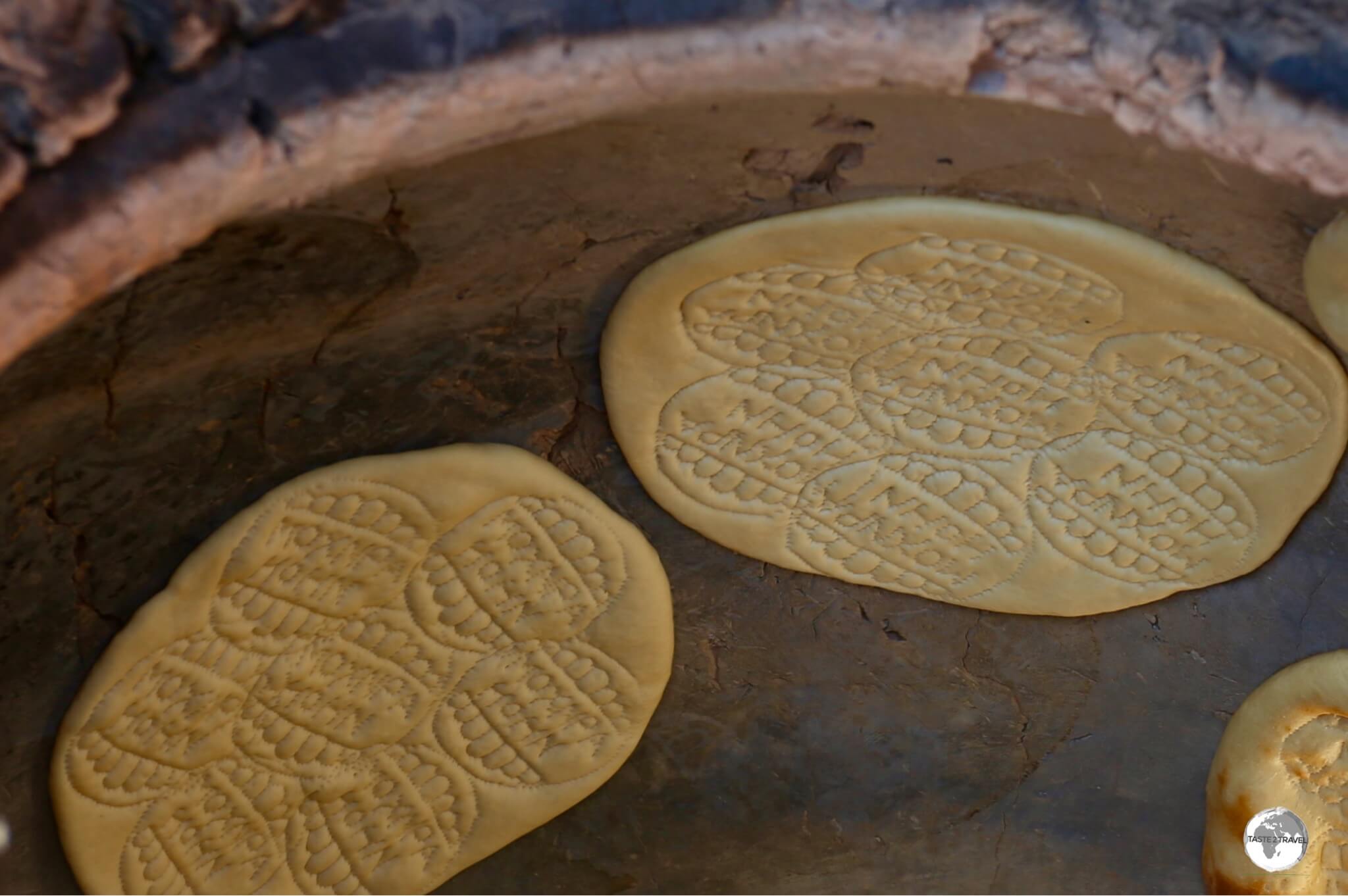 The bread is slapped to the sides of the clay oven where it remains until its golden brown and toasty.