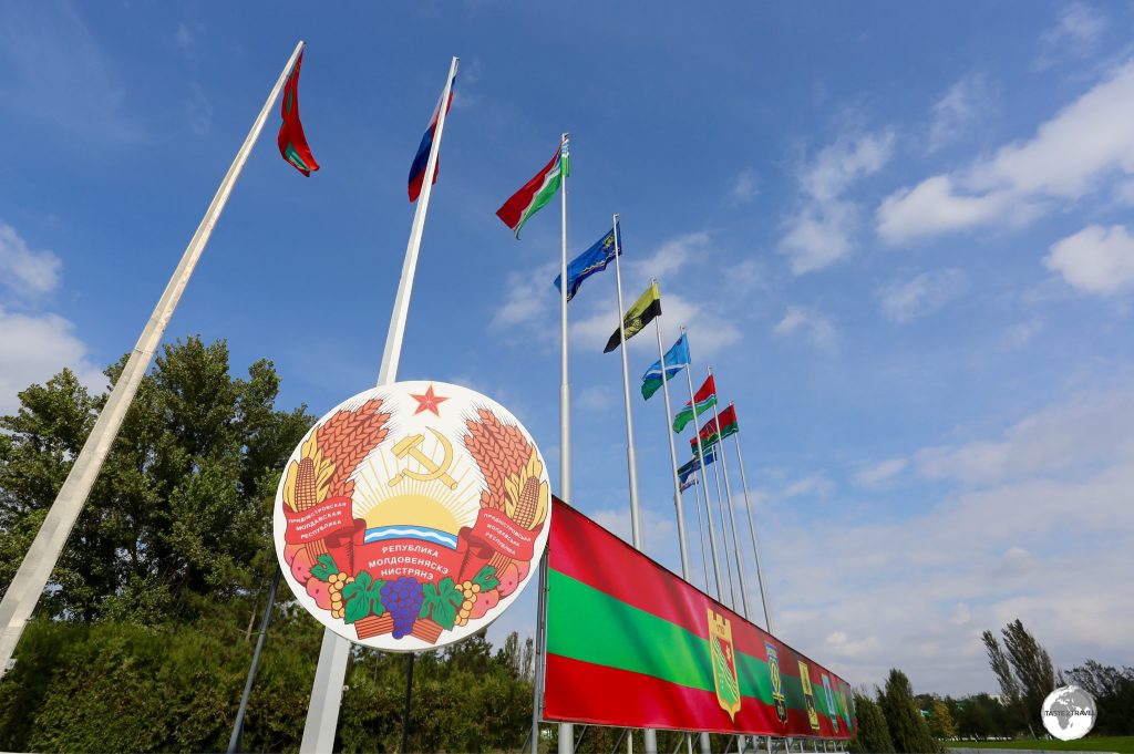 The coat of arms of Transnistria with the flags of (l-r) Transnistria, Russia and the different districts of Transnistria.