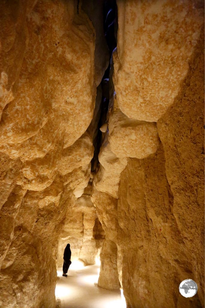 A visitor inside one of the cavities of Al Qarah Mountain.