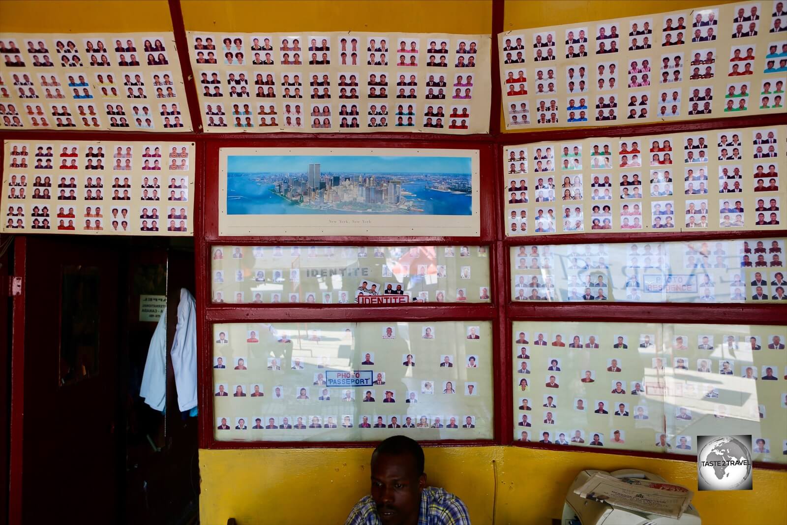 Passport photos line the wall of a photo studio in downtown PAP.