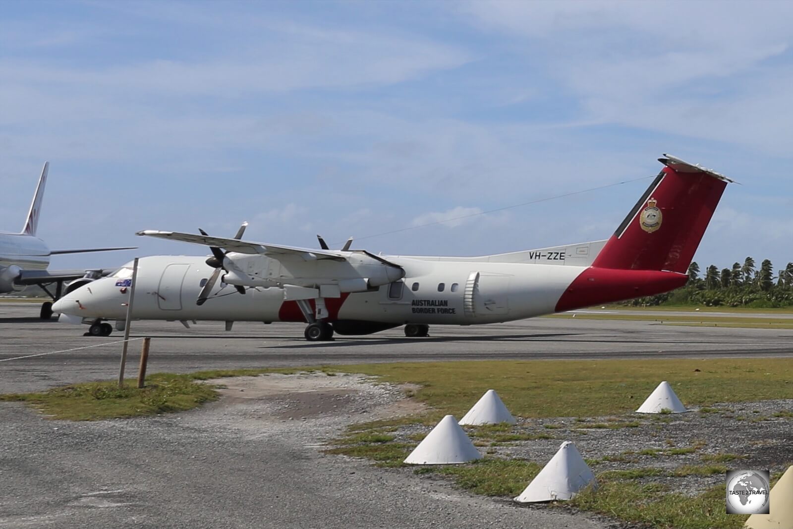 A Dash-8 surveillance plane, operated by Australian Border Force, parked on the runway at Cocos (Keeling) Airport.