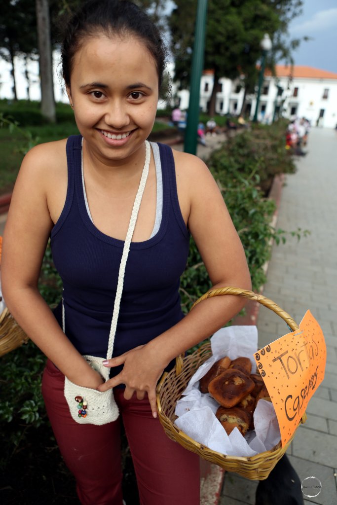 A cake seller in Parque de Caldas, the main square of the historic city of Popayán, a small colonial-era city known for its chalk-white façades.