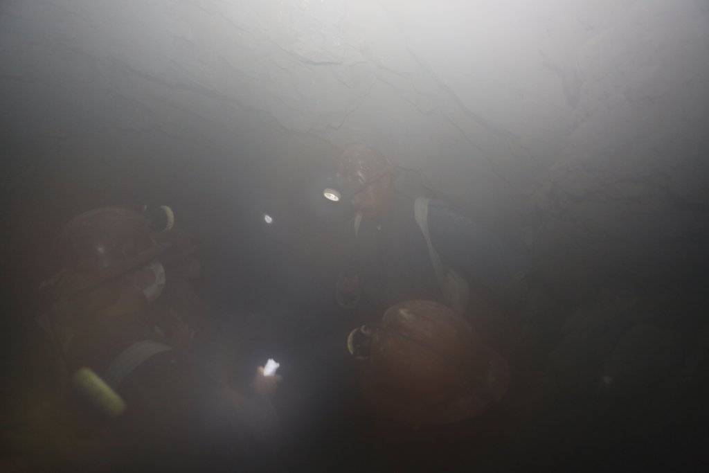 Helmet lights, from the members of our tour group, are all that can be seen through the toxic, eye-watering, dust after a nearby explosion of dynamite.