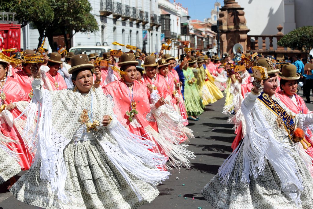 Most older women who participate in the 'Fiesta de la Virgen de Guadalupe' wear traditional costumes, which include bowler hats, shawls, and long skirts.