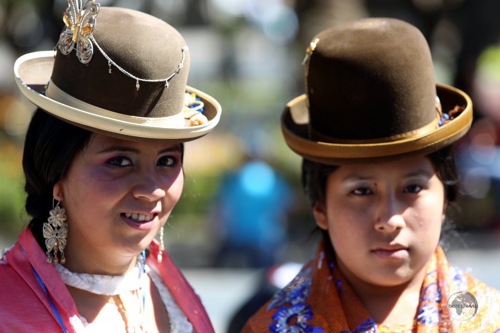 Participants in the 'Fiesta de la Virgen de Guadalupe' parade in Sucre, wearing traditional bowler hats and shawls.