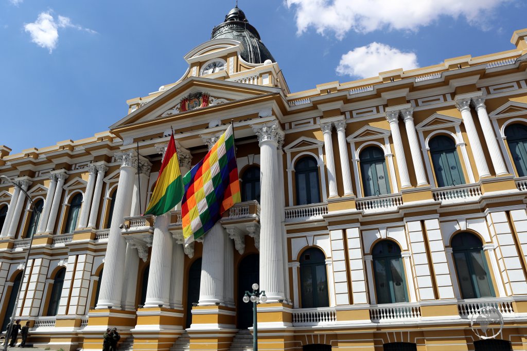 The official Bolivian flag and the multi-coloured 'Wiphala of Qulla Suyu', the official variant flag of Bolivia, fly outside the Bolivian Legislative Assembly building in La Paz.