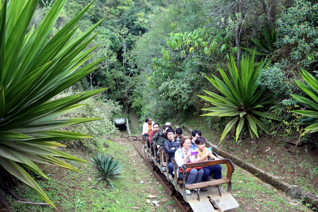 Tourists enter the depths of the 'Pasagem de Mariana' gold mine riding on the same rickety rail system which once transported miners into the mine.