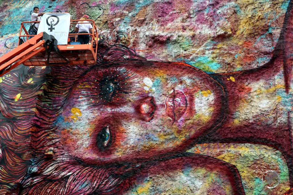 Street art being painted on the side of a building in downtown Rio de Janeiro.