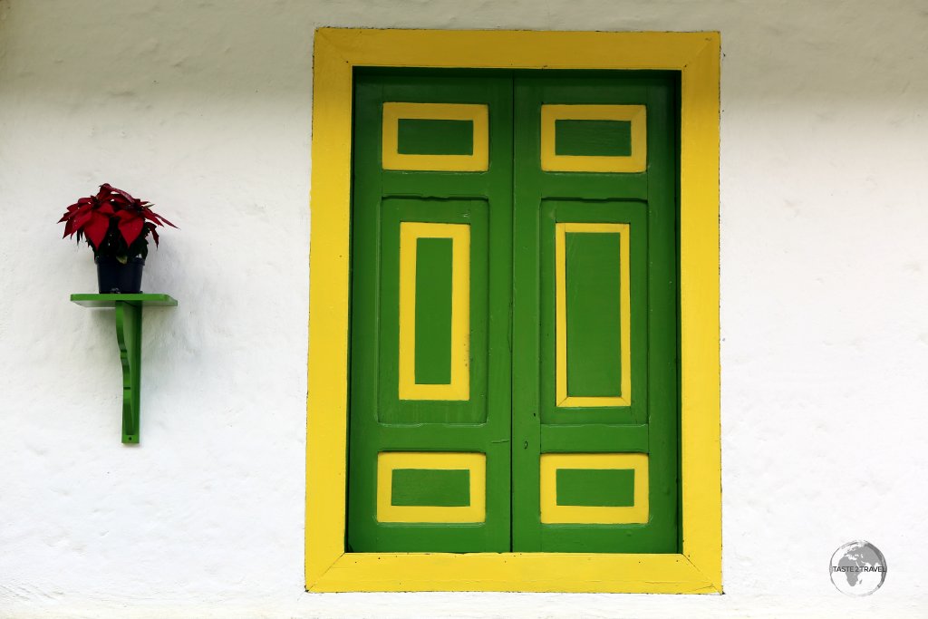A typical bahareque-style of building in Salento, with stark white walls and brightly painted wooden shutters. With a lack of clear windows, interiors are always dark!