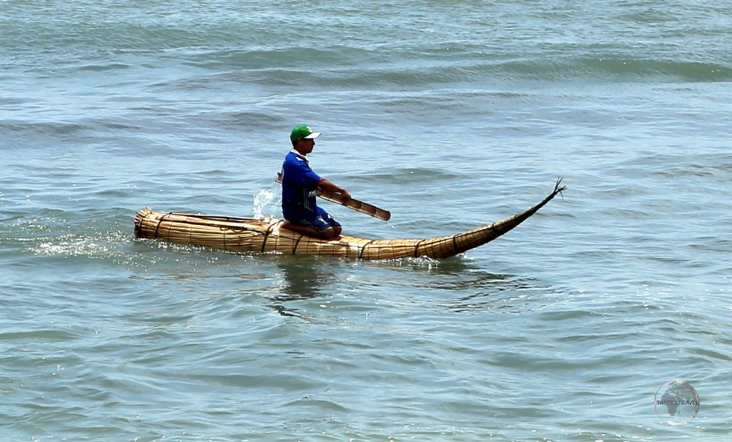 A fisherman at Huanchaco beach, paddling his 'Caballito de Totora' raft, a raft which has existed, unchanged, for more than 3,000 years but is fast disappearing.