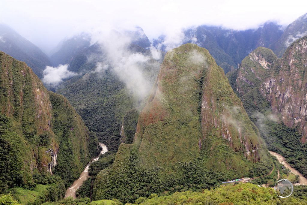 Machu Picchu is dramatically situated on a ridge, high above the Urubamba River and the Sacred Valley, 80 km (50 mi) northwest of Cusco, Peru.