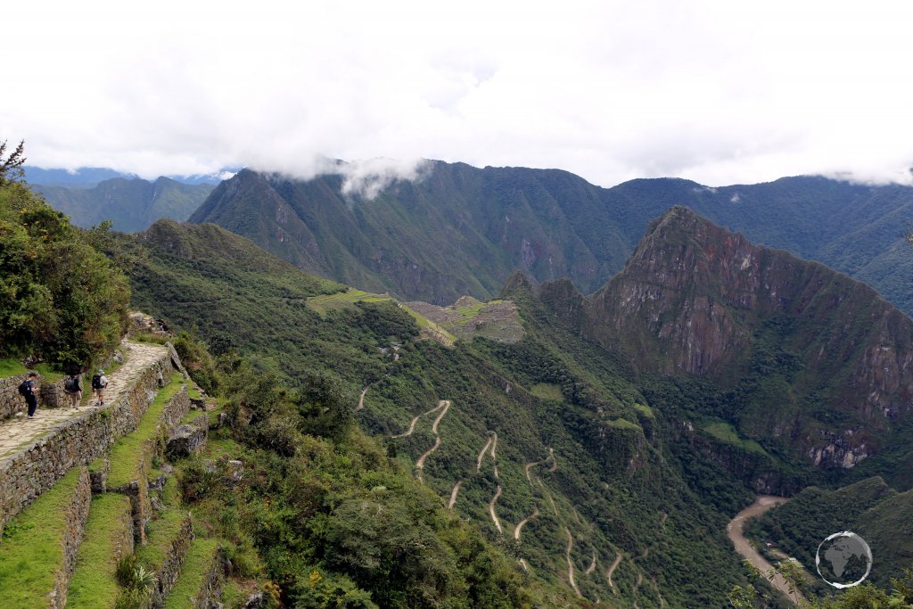 A view from the Inca trail, high in the Peruvian Andes, of a very distant Machu Picchu and the access road winding its way up the mountain from the Urubamba River.