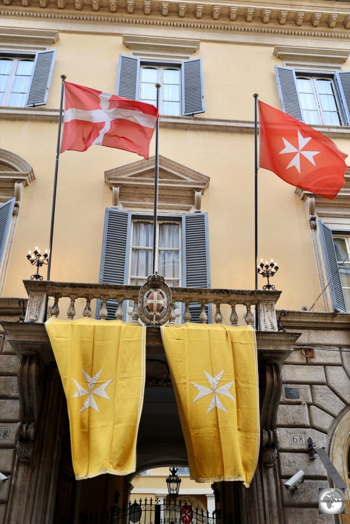 The two flags of the Order of Malta, above the main entrance to the Magistral Palace on Via dei Condotti.