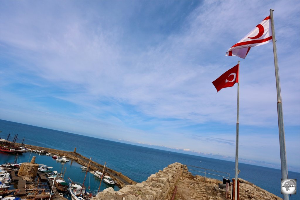 The flags if Turkey and Northern Cyprus flying on top of the ramparts at Kyrenia castle.