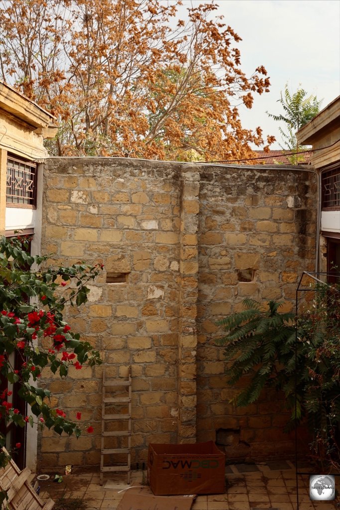 A laneway in North Nicosia old town is blocked by a section of wall which includes a ladder and two peep holes.