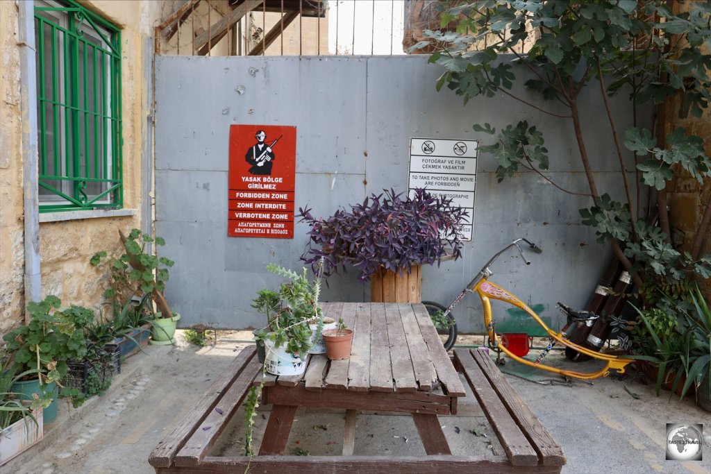 Garden furniture outside a residential building in North Nicosia softens the affect of the steel wall of the UN Buffer zone.