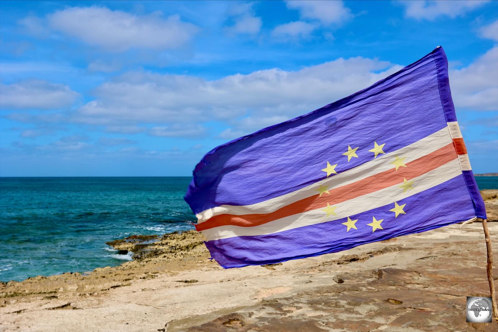 The flag of Cape Verde flying on the rocky coast at Murdeira, Sal Island.